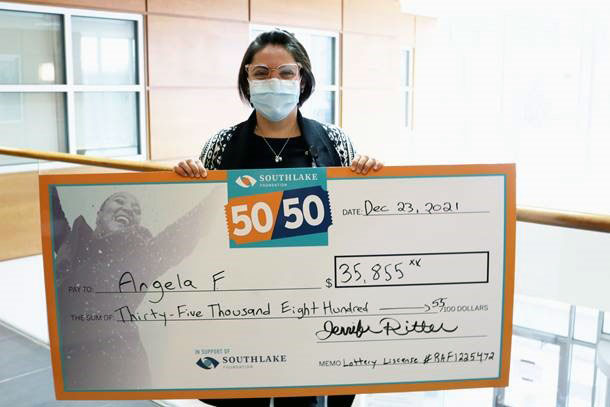 Angela holding a cheque.