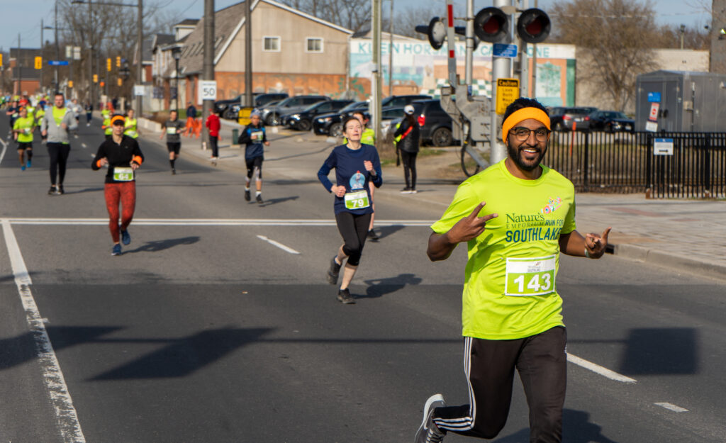 Man smiling crossing the finish line.