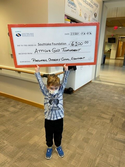 Atticus holding his donation cheque