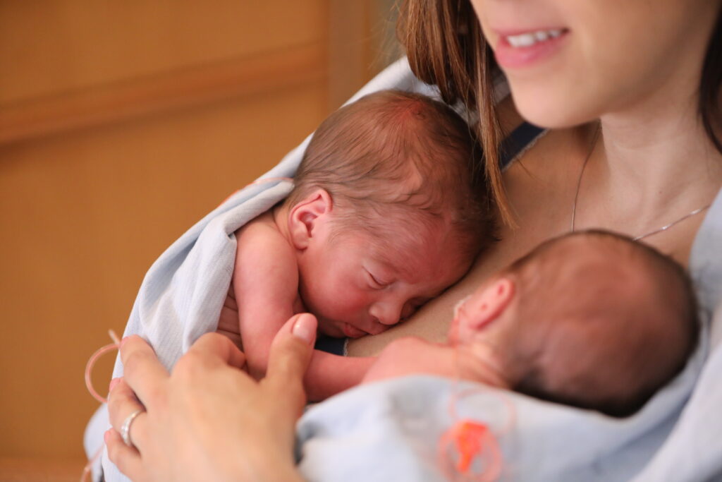 Mother holding newborn twins